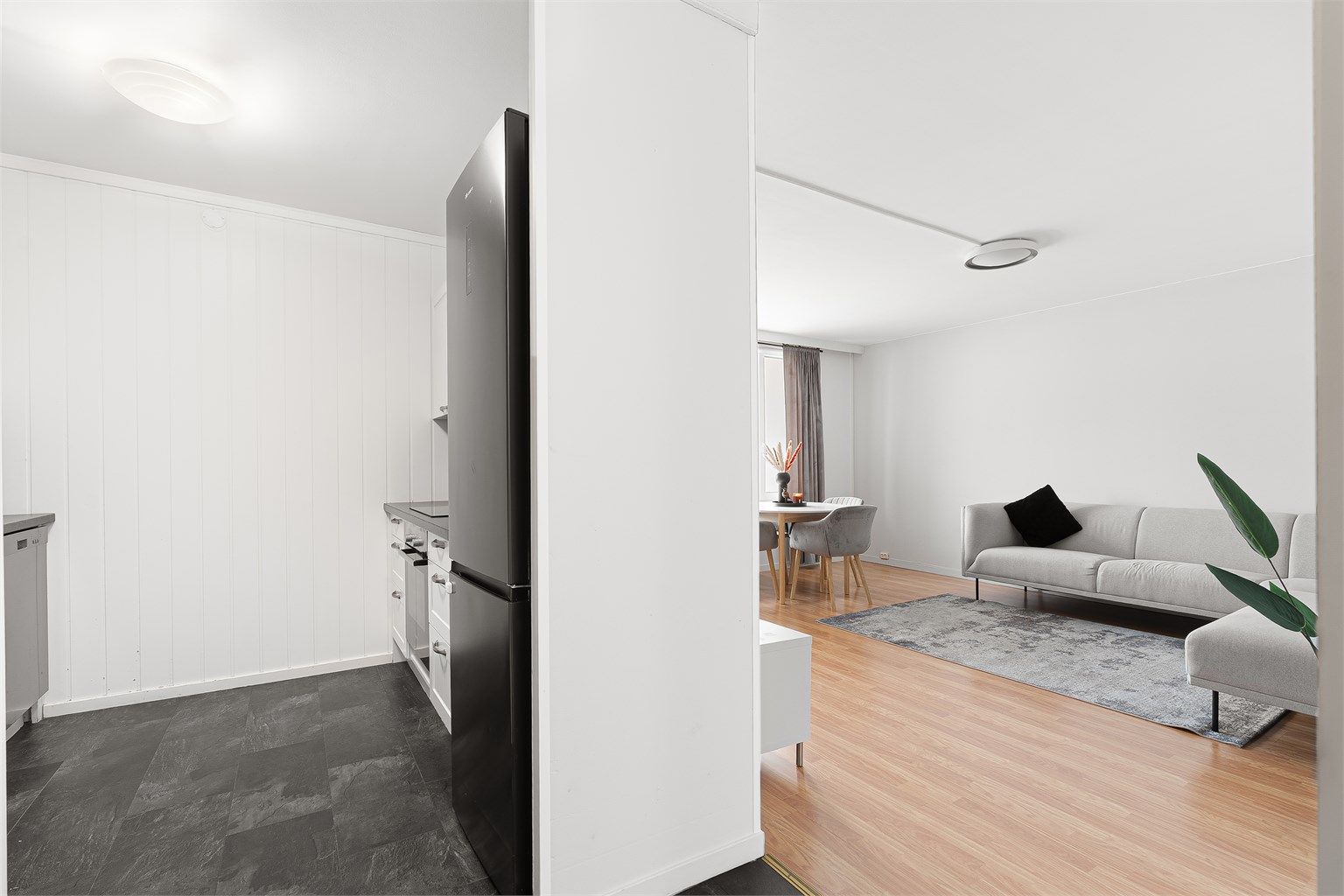 Kjøkkenet ligger naturlig tilbaketrukket fra stuen og er innredet med lyse slette fronter og benkeplate av laminat. 