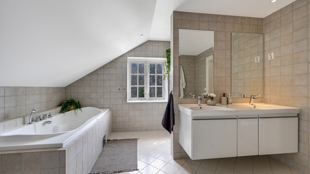Badet er lekkert flislagt og har en gjennomgående stil.