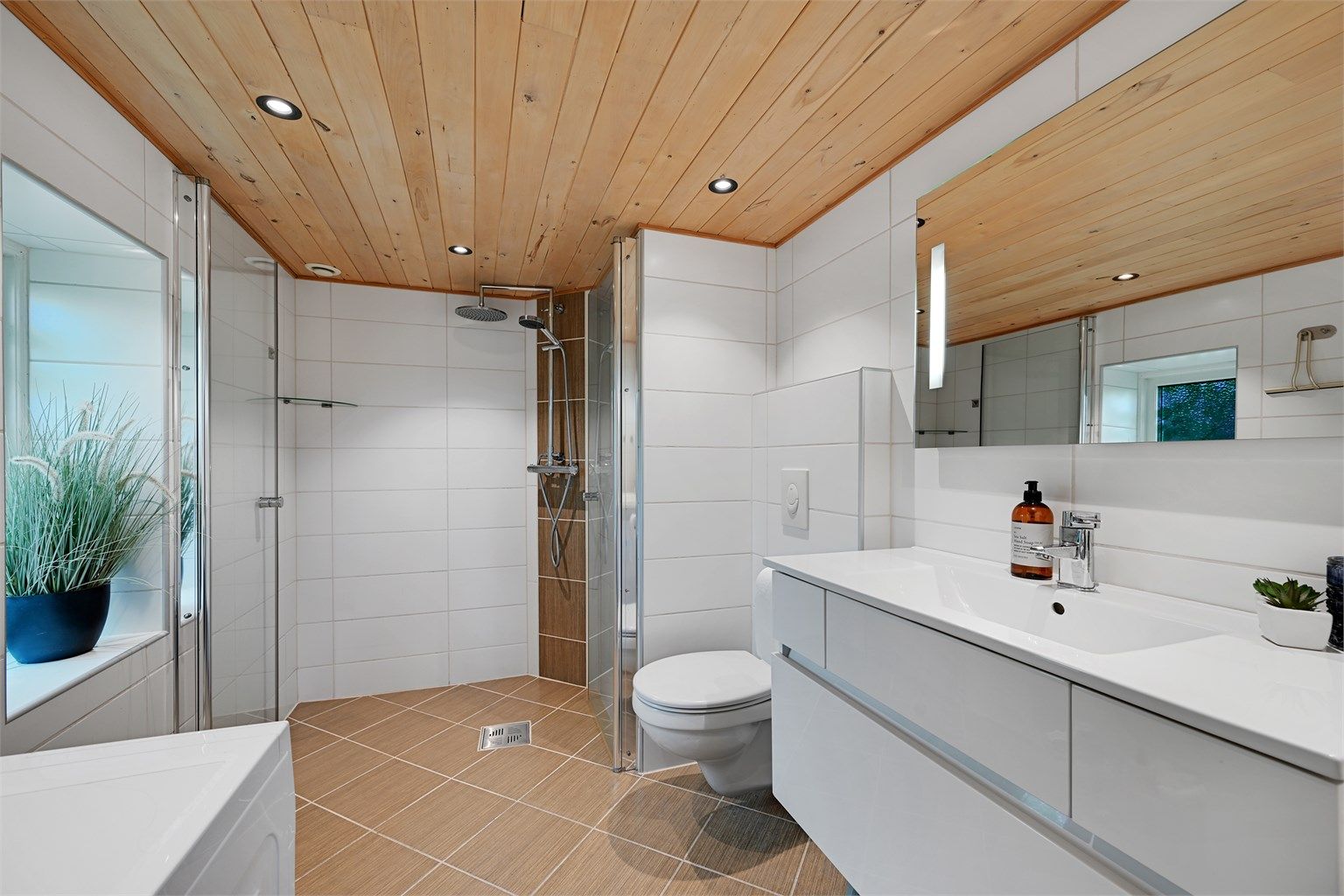 Badet fra 2012 er moderne og delikat innredet med heldekkende servant, vegghengt toalett, dusj med glassvegger og opplegg for vaskemaskin.