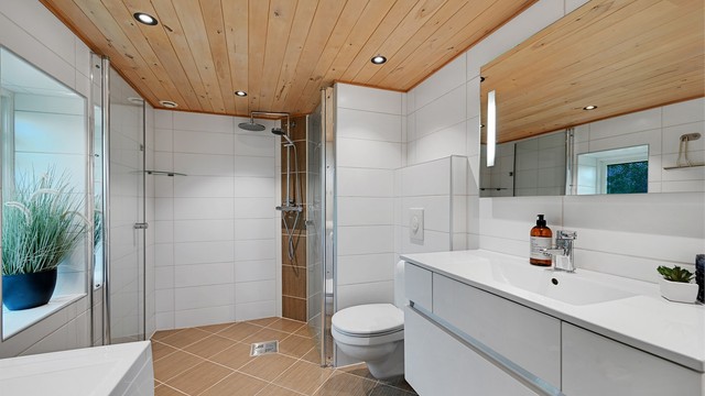 Badet fra 2012 er moderne og delikat innredet med heldekkende servant, vegghengt toalett, dusj med glassvegger og opplegg for vaskemaskin.