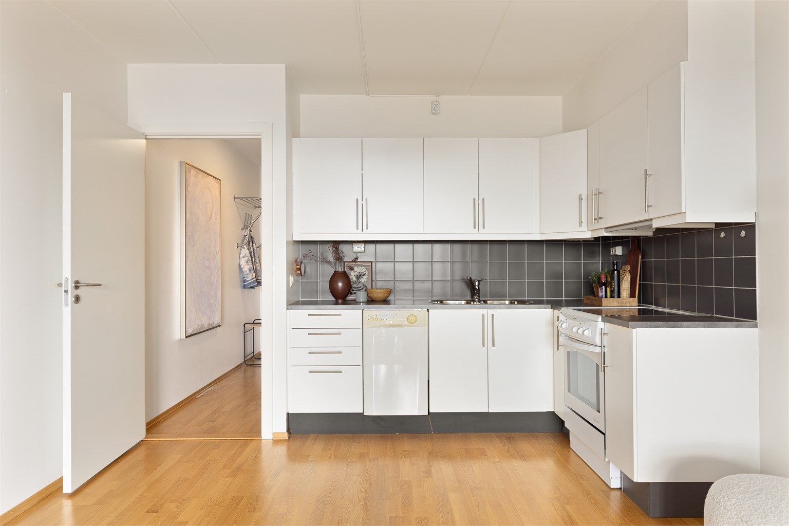 Kjøkkenet er fra byggeår og har tidløse glatte fronter, praktisk laminatbenkeplate og integrert ventilator i overskap.