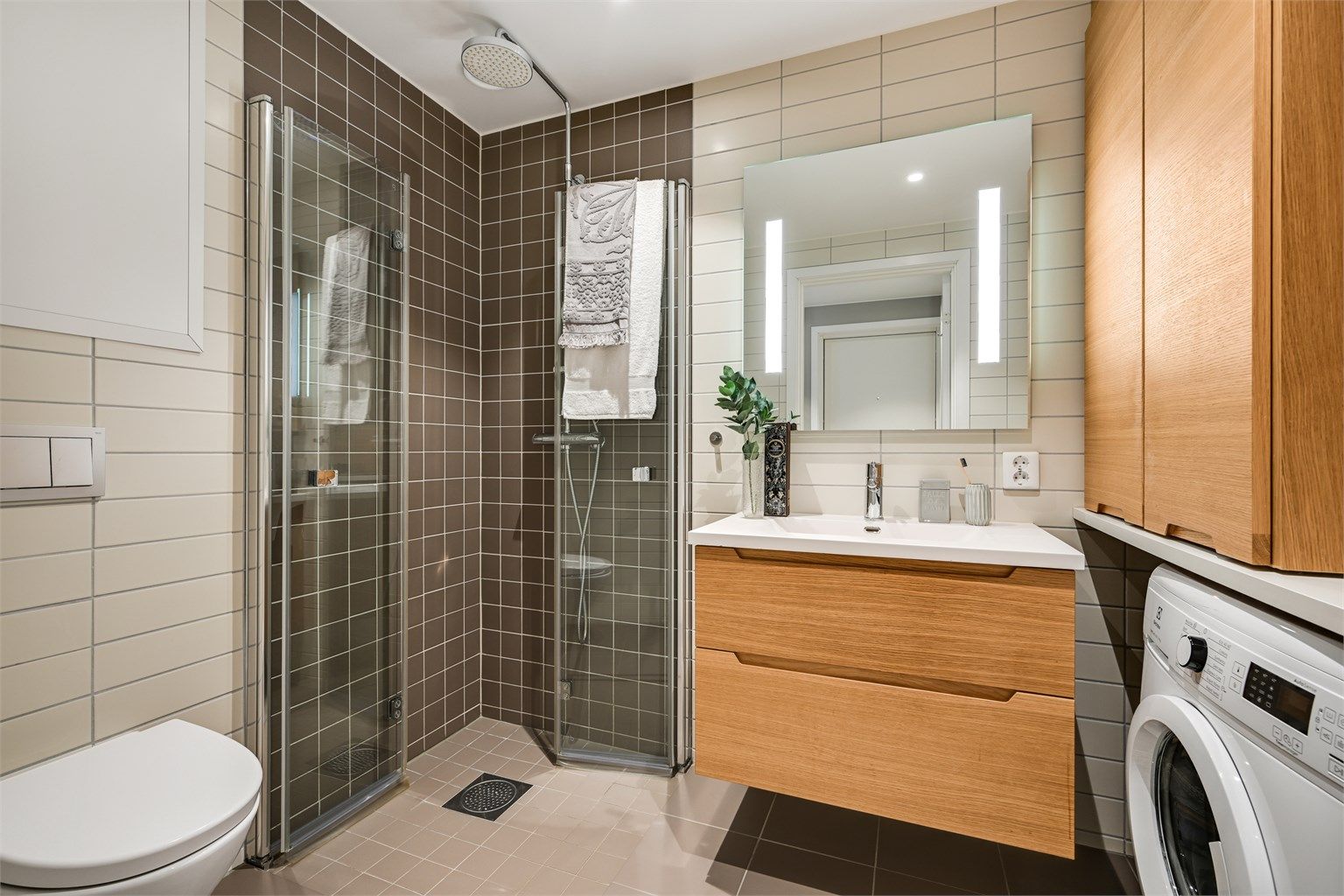 Det er innredet med en delikat servant med skuffer under, spotter i taket, toalett og dusjhjørne med innfellbare glassdører. 