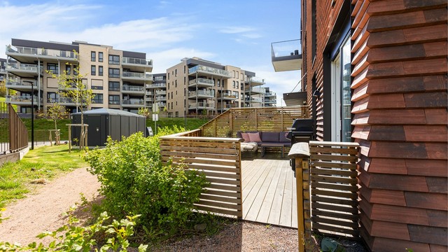 Terrassen er pent opparbeidet med levegg og gode møbleringsmuligheter for både spisegruppe og loungeområde.