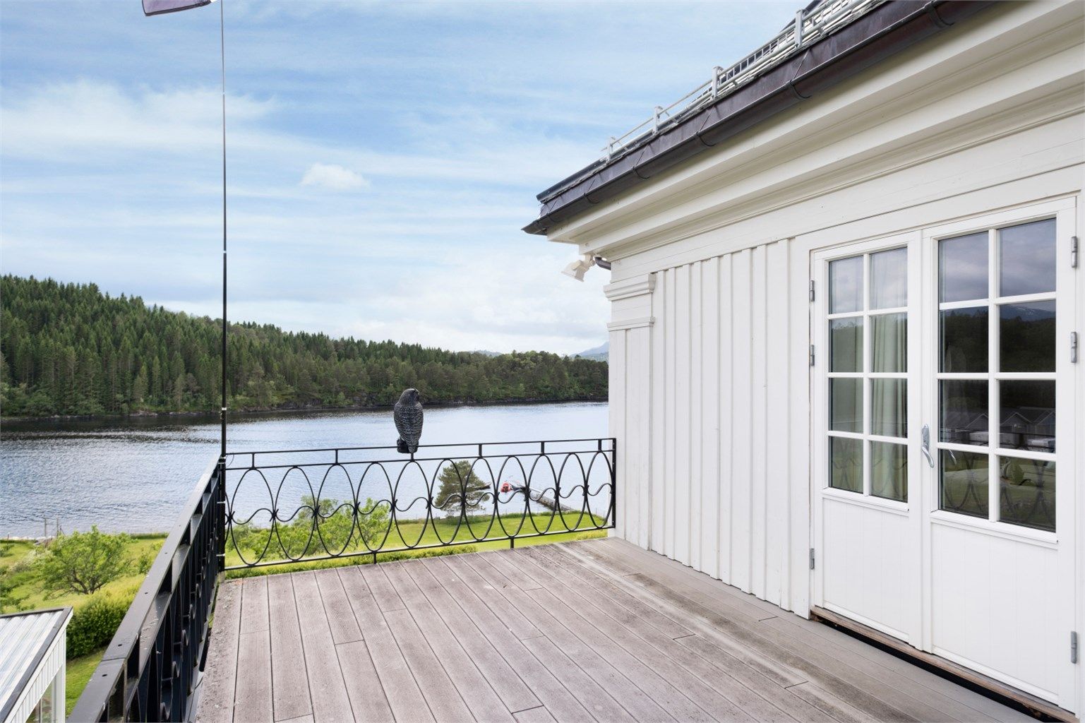 En tofløyet balkongdør i tre med 2-lags isolerglass åpner opp mot terrassen fra hovedsoverommet