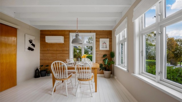 Spiseplassen ligger lyst til ved vinduet med trefasade på endeveggen.