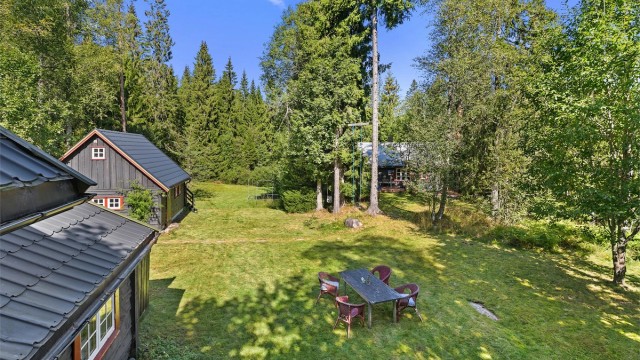 Tunet med to hytter og en garasje, stor tomt bestående av to gnr og bnr.
