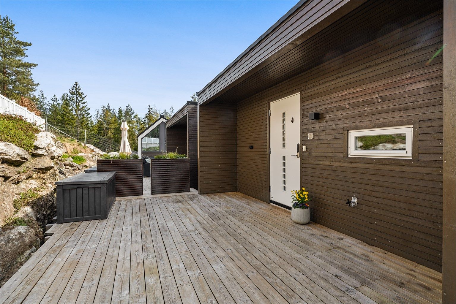 Den store plattingen ved inngangspartiet fungerer som en forlengelse av boligen på varme dager.