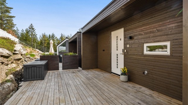 Den store plattingen ved inngangspartiet fungerer som en forlengelse av boligen på varme dager.