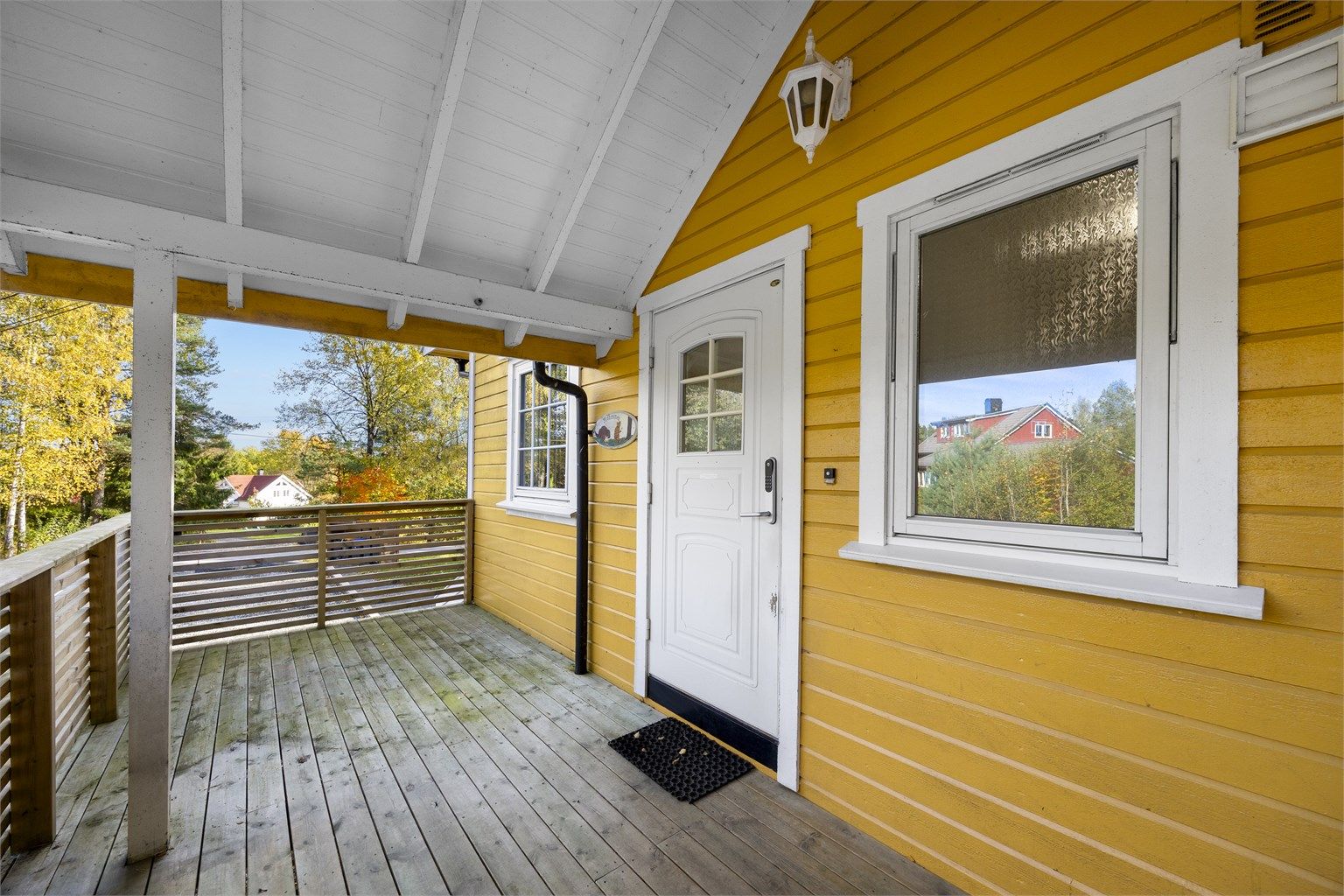 Overbygget inngangsparti med terrasse og adkomst til boligens hovedentré.