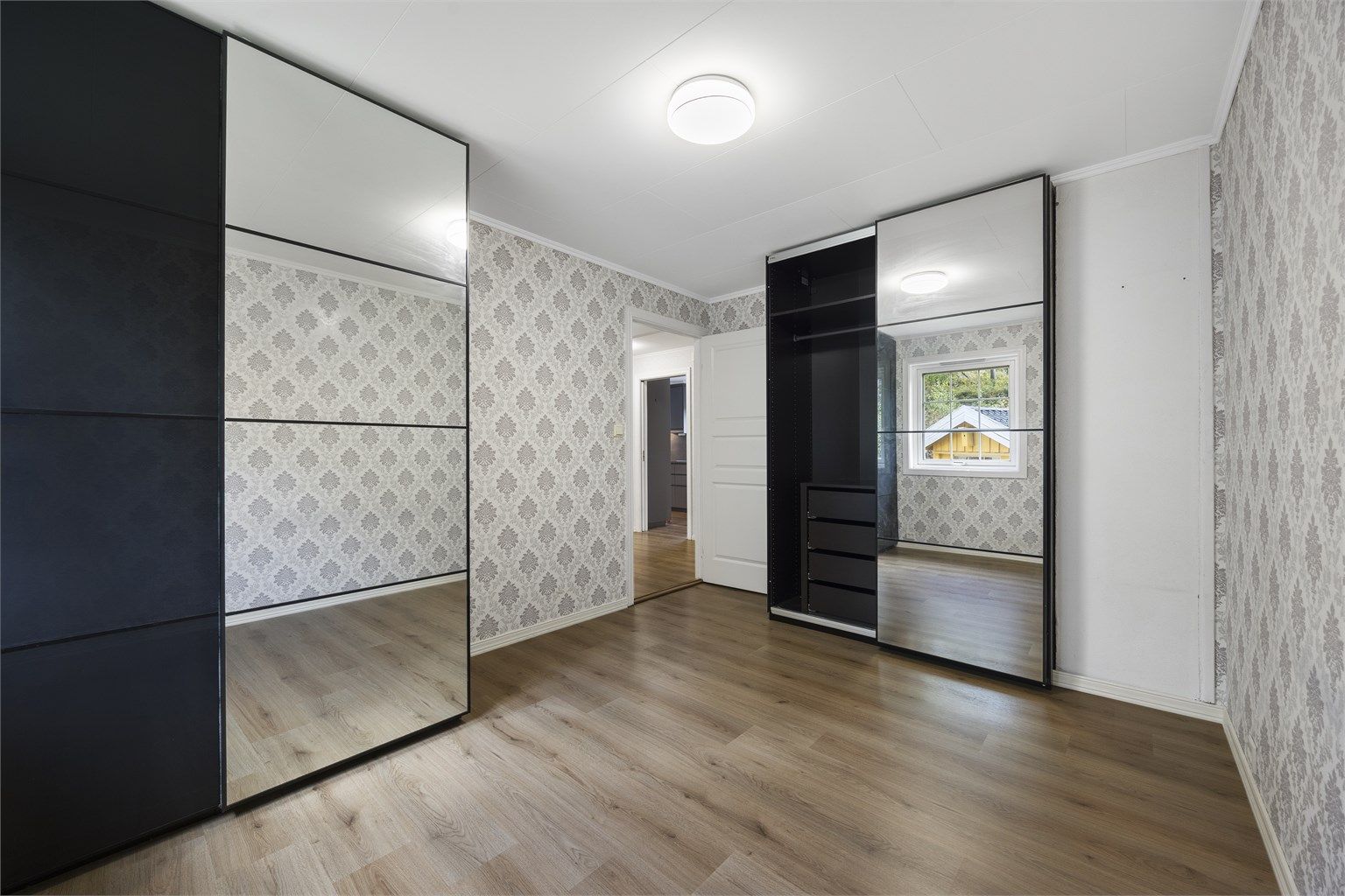 Rommet er innredet med en stor garderobe med speilskyvedører.