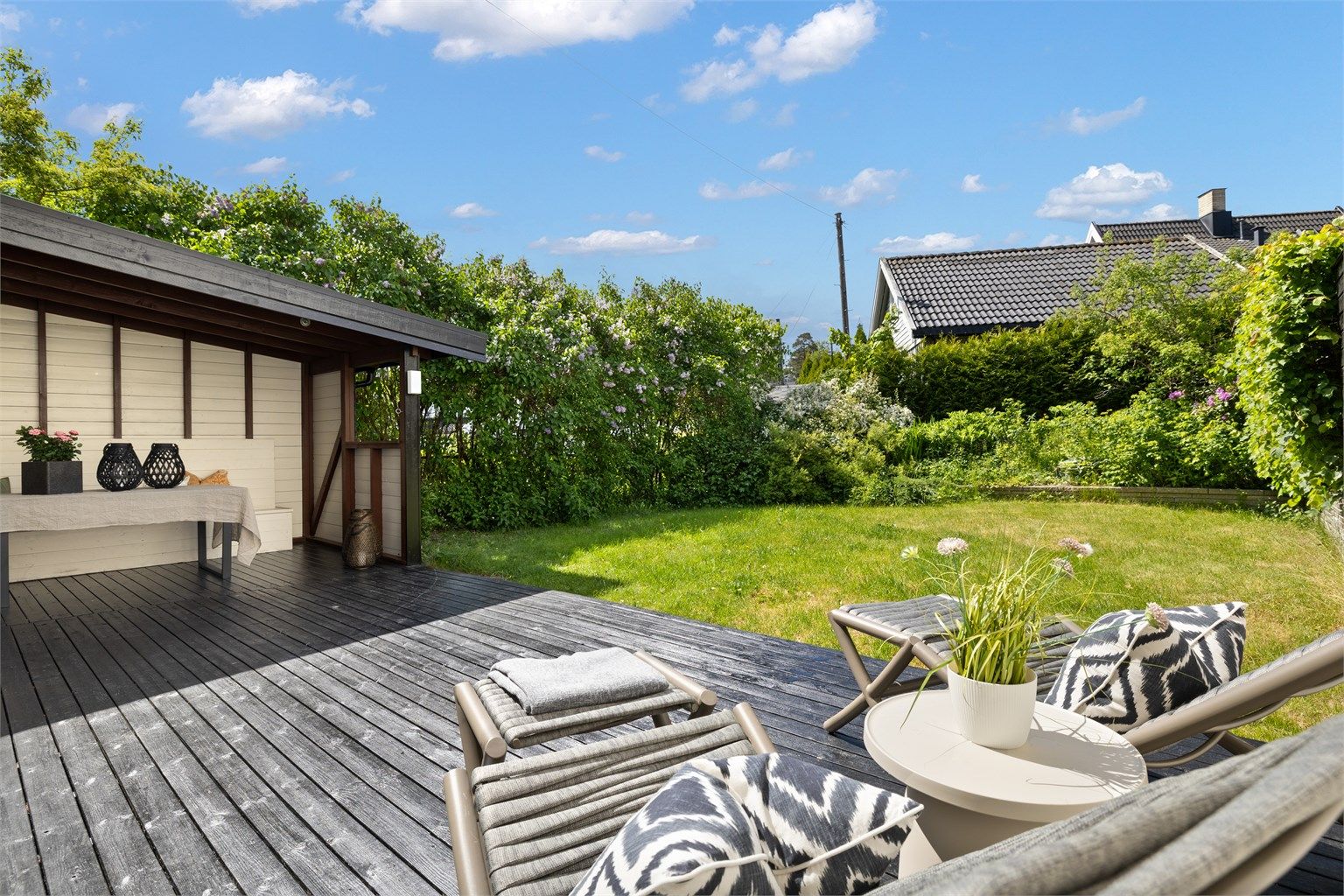 Vestvendt terrasse på hele 36 kvm, hvor deler er overbygget – perfekt for både solrike dager og sene sommerkvelder, samt god boltreplass i hagen.