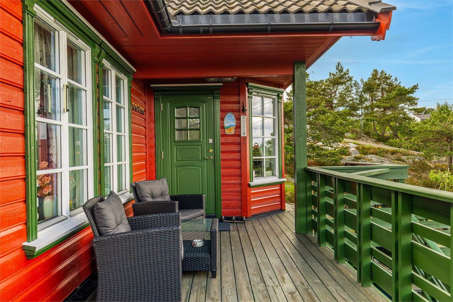 Verandaen strekker seg rundt hytta og vender mot øst, syd og vest. Her ved inngangspartiet som er overbygget.