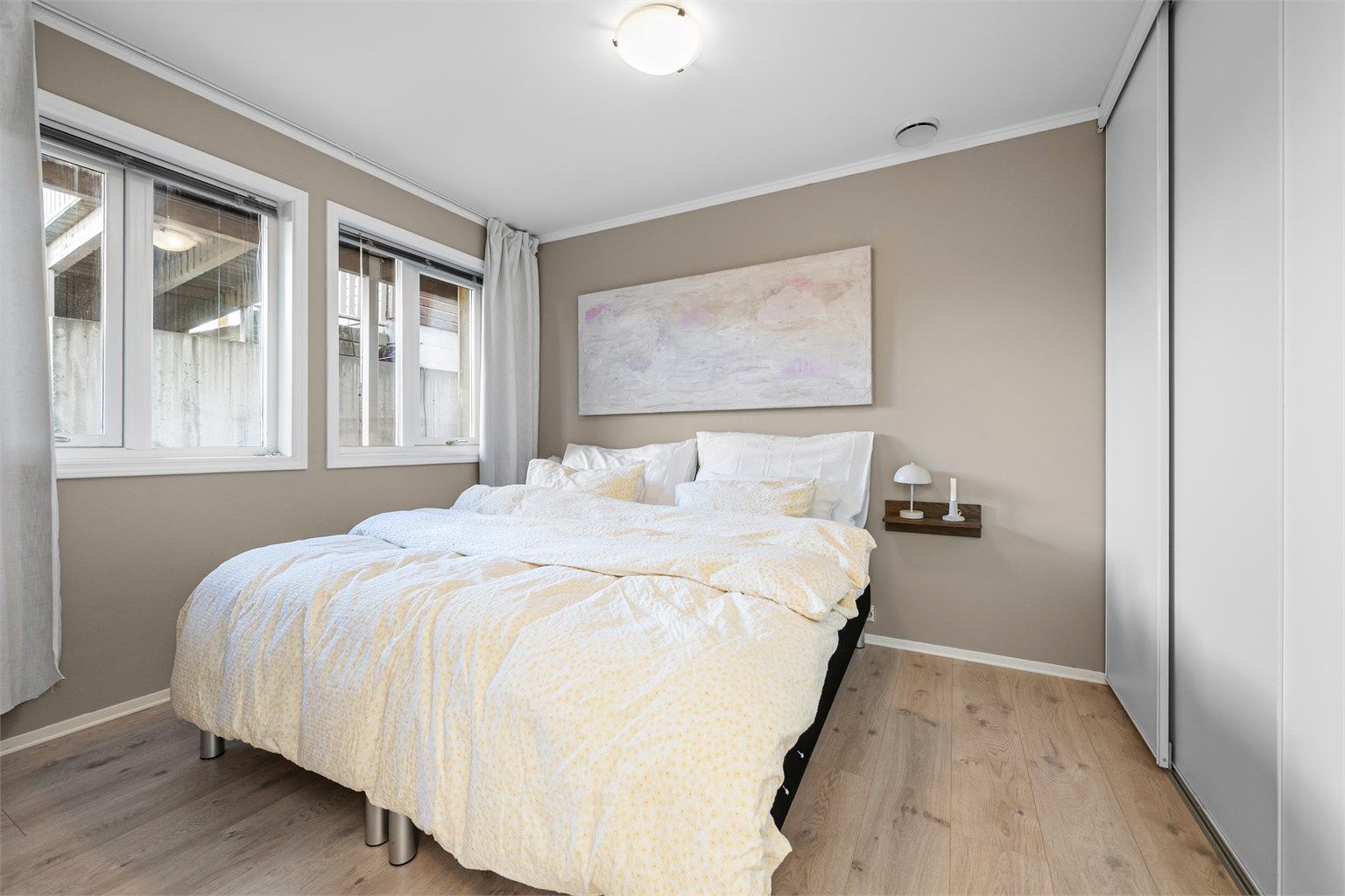 Hovedsoverom med en-stavs laminat fra 2020 og romslig skyvedørsgarderobe.