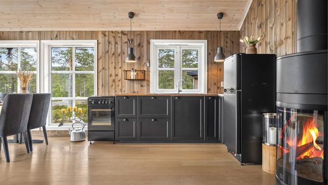 Svart IKEA kjøkkeninnredning med profilerte fronter og benkeplater av laminert heltre.