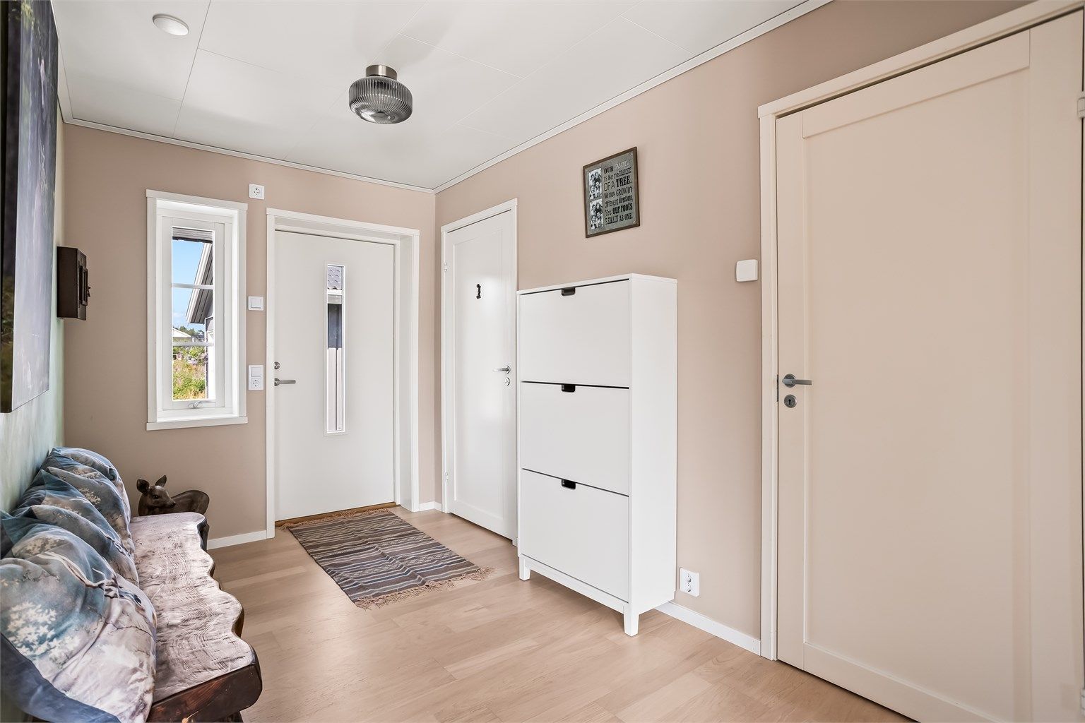 Velkommen inn i en romslig entré med rikelig med plass til sko og yttertøy.