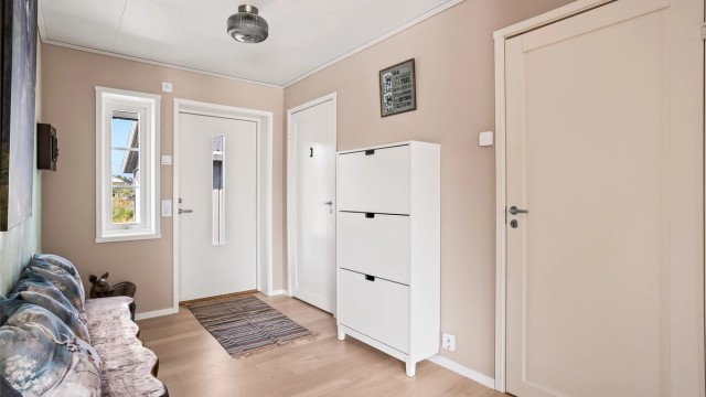 Velkommen inn i en romslig entré med rikelig med plass til sko og yttertøy.