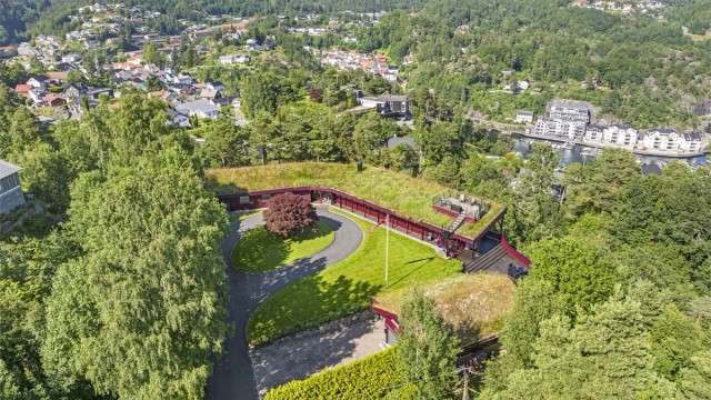Lekkert, parkmessig opparbeidet uteområde med flere uteplasser.