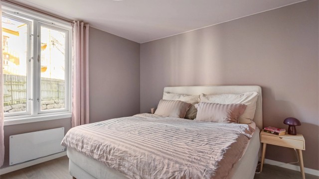 Soverommet har en god størrelse og vender mot den rolige bakgården, noe som gir en behagelig og skjermet atmosfære.