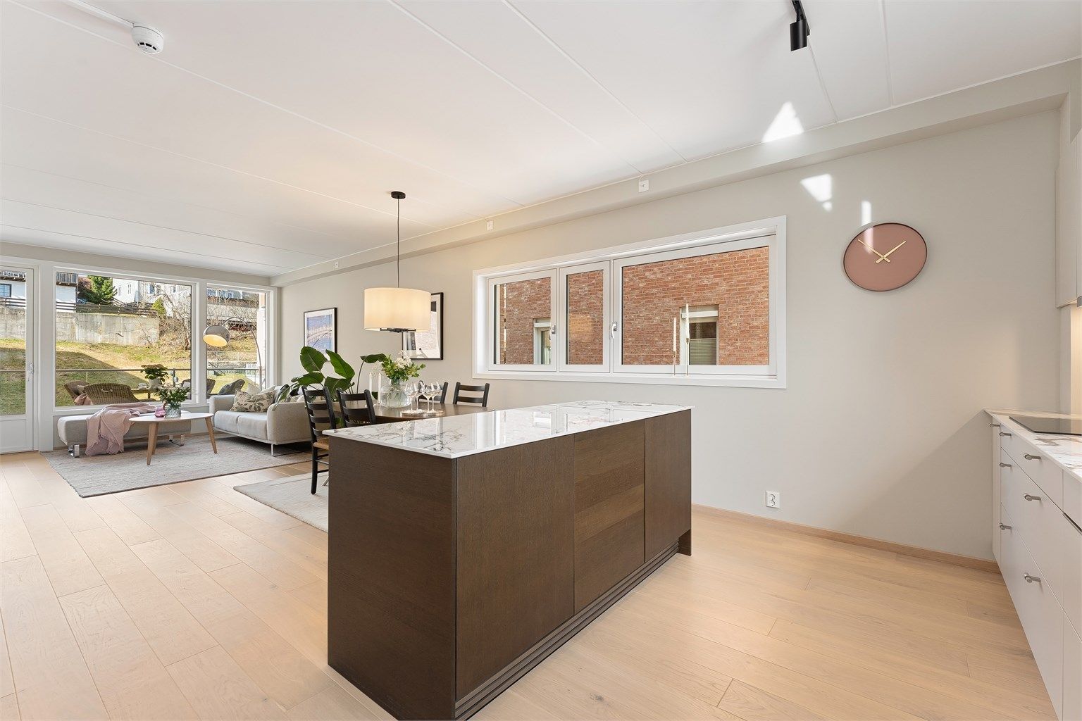 Lys og luftig stue med åpen kjøkkenløsning. Oppholdsrommet har lysinnslipp fra tre vegger