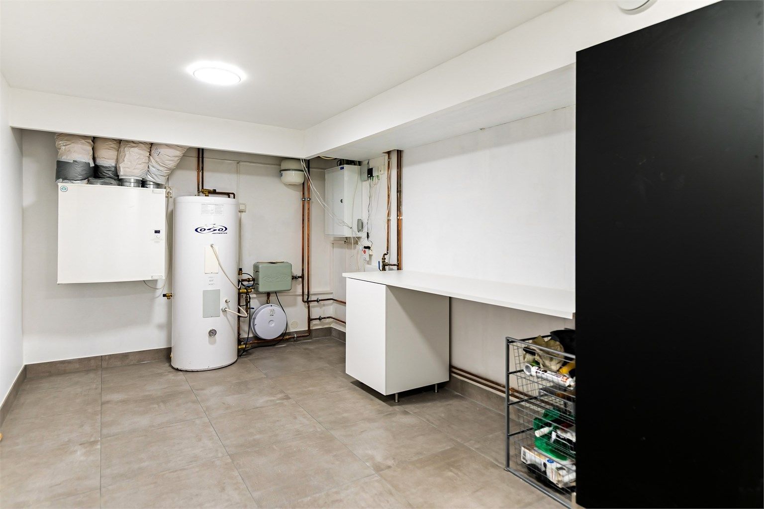 Teknisk rom med varmtvannsberedere, ventilasjonsaggregat og fordelerskap.
