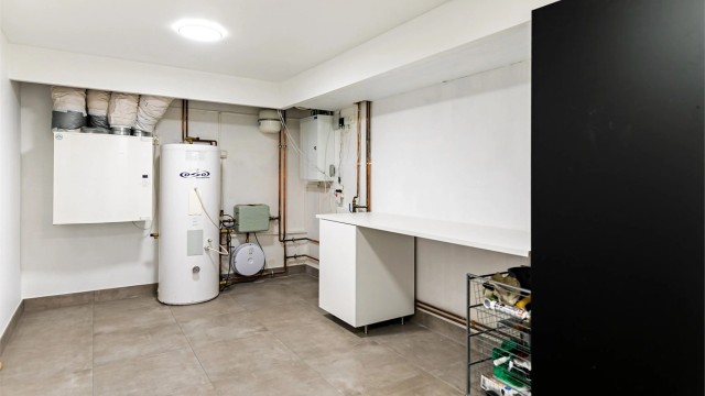 Teknisk rom med varmtvannsberedere, ventilasjonsaggregat og fordelerskap.