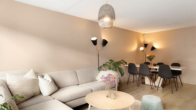 Stuen har god plass til både sofakrok og spisestue med langbord, perfekt for familiemiddager og hyggelige samlinger.
