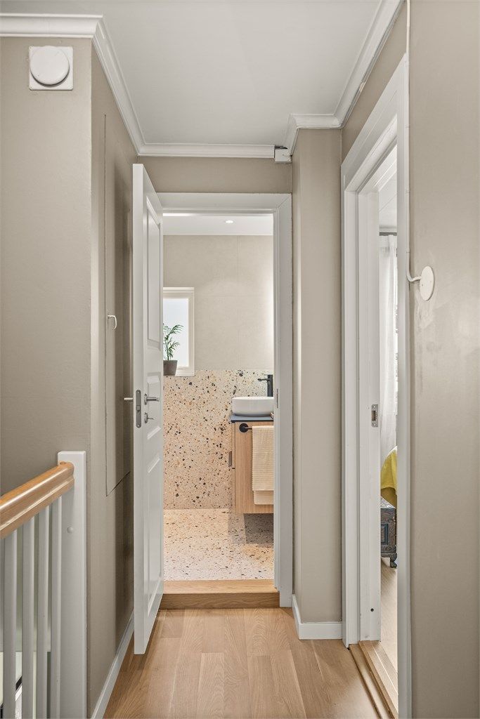 Trappen leder opp til en gang med adkomst til tre soverom, bad og kott.