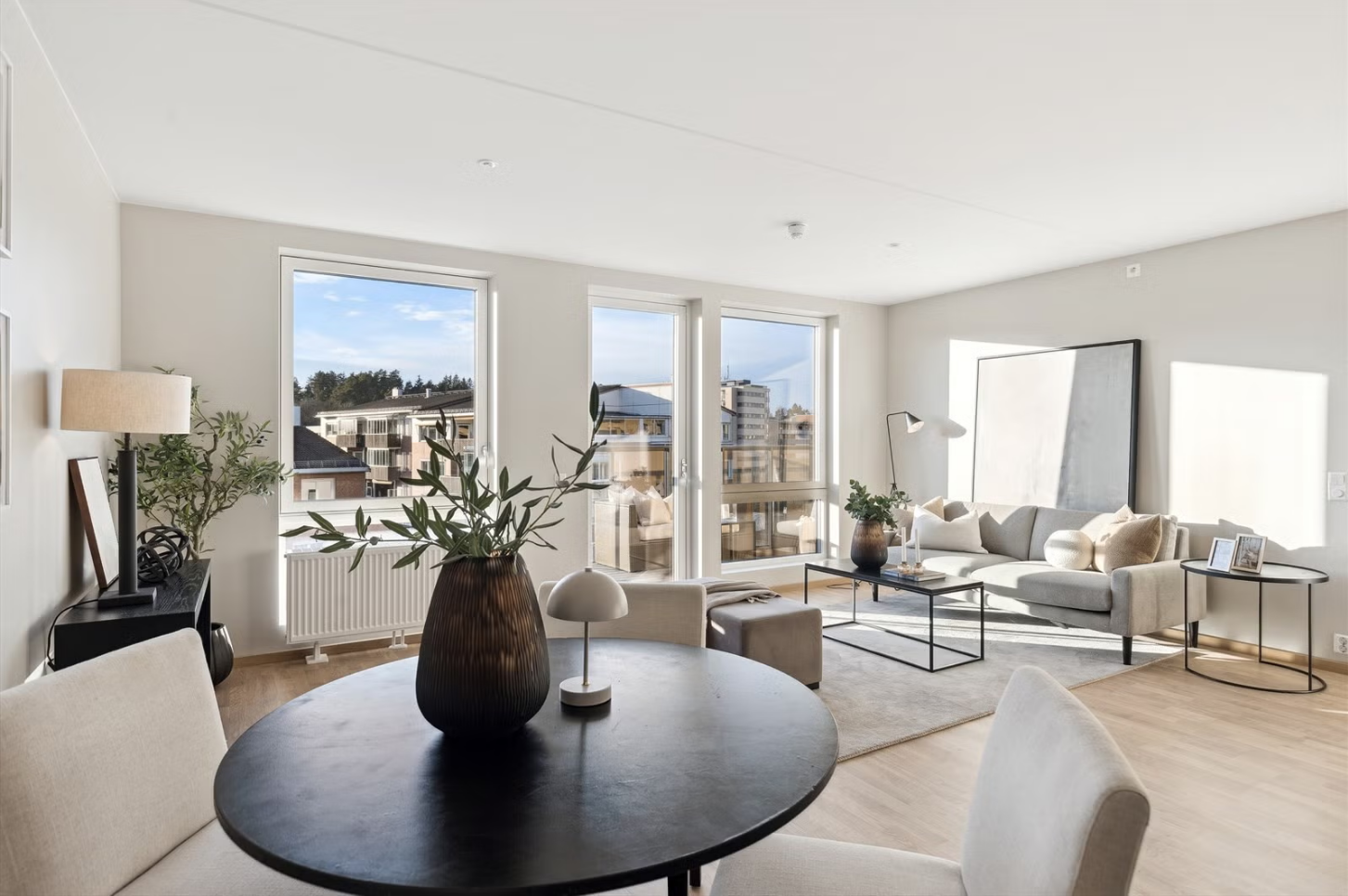 Lys og luftig stue med store vindusflater og utgang til balkong som gir rikelig med naturlig lys.