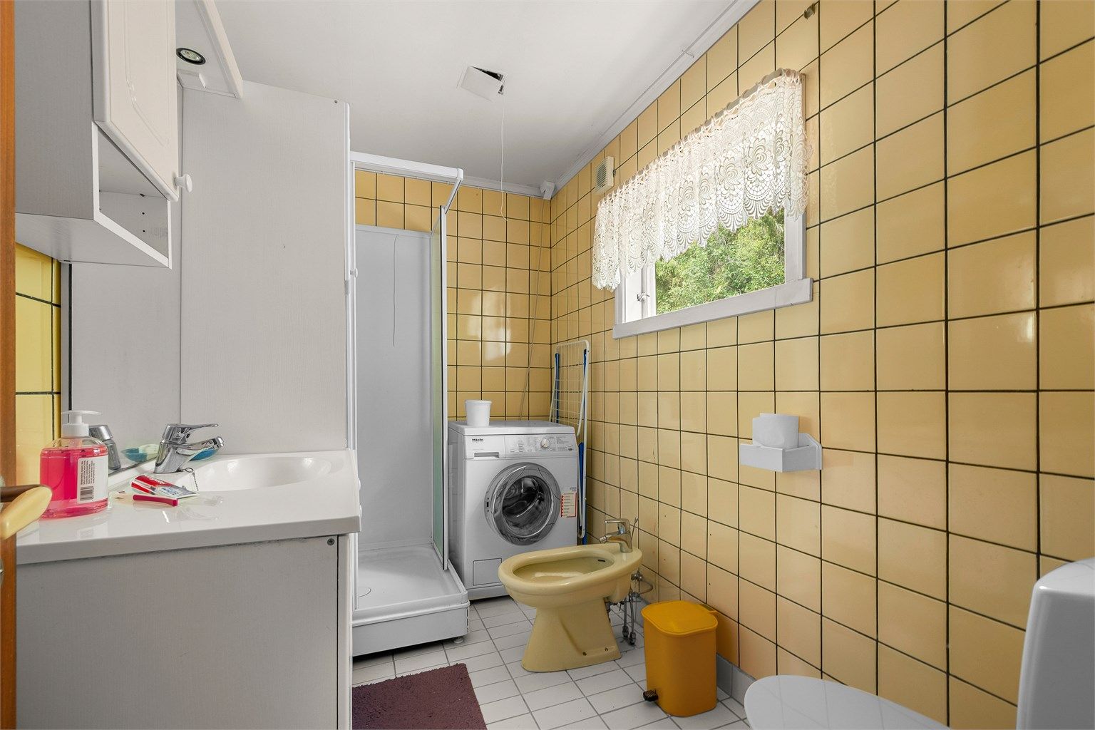 Badet er innredet med servant, toalett, dusj og opplegg for vaskemaskin.