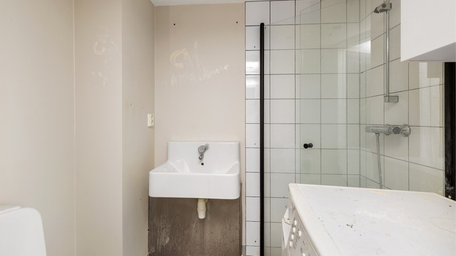 Bad med fliser på gulv og dusjnisje med varmekabler