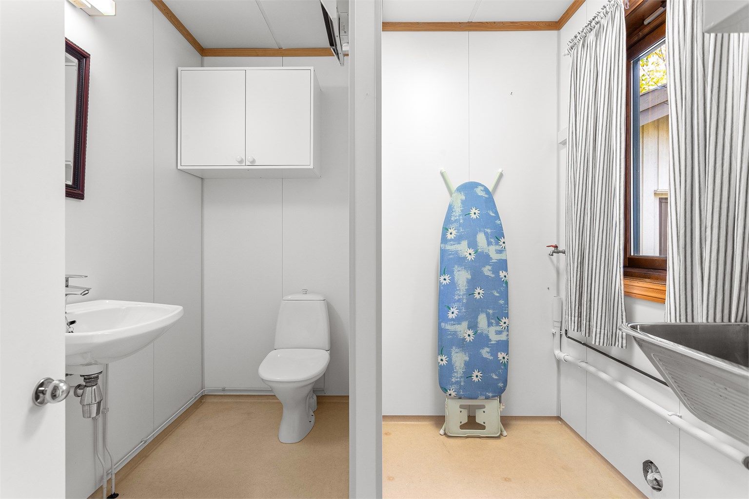 Vaskerom med belegg på gulv og våtromsplater på vegger. Innredet med servant og vegghengt utslagsvask. Gulvstående toalett og opplegg for vaskemaskin/tørketrommel.