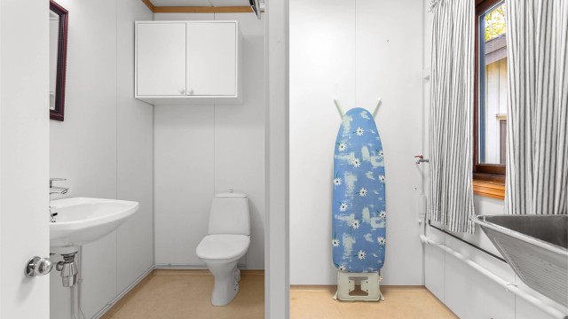 Vaskerom med belegg på gulv og våtromsplater på vegger. Innredet med servant og vegghengt utslagsvask. Gulvstående toalett og opplegg for vaskemaskin/tørketrommel.