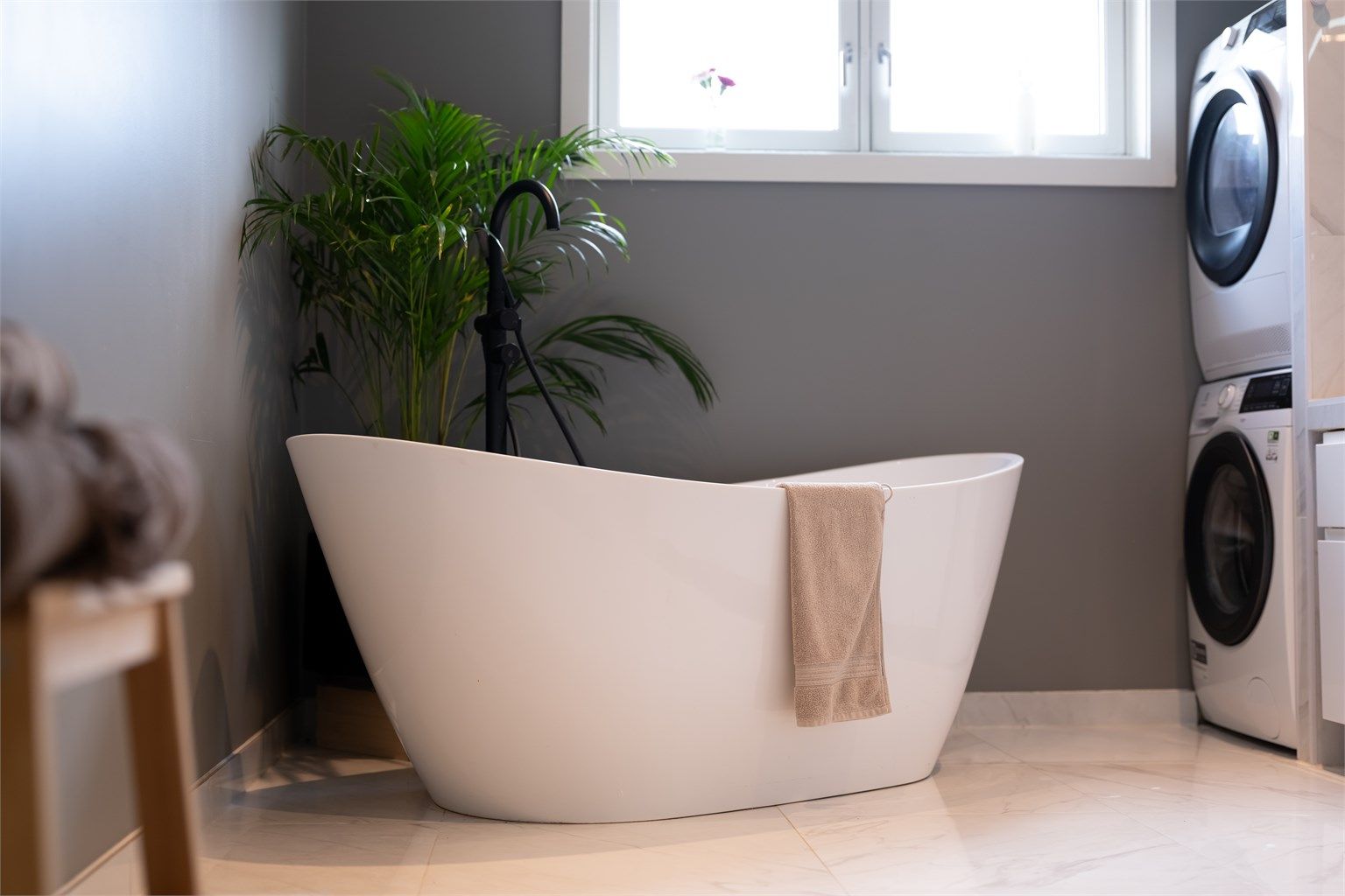 Videre er det badekar og opplegg for vaskemakin og tørketrommel.