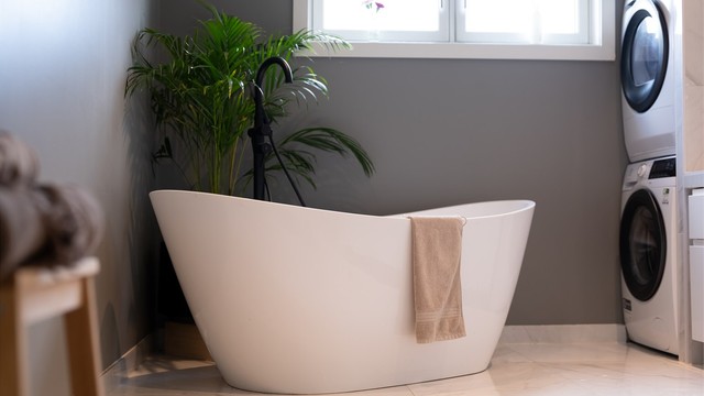 Videre er det badekar og opplegg for vaskemakin og tørketrommel.