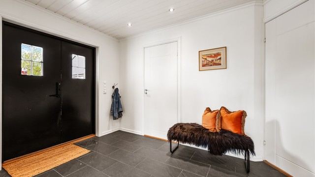 Entré med flislagt gulv, gulvvarme og innfelte downlights i himlingen. Herfra er det utgang til en platting ved inngangspartiet.