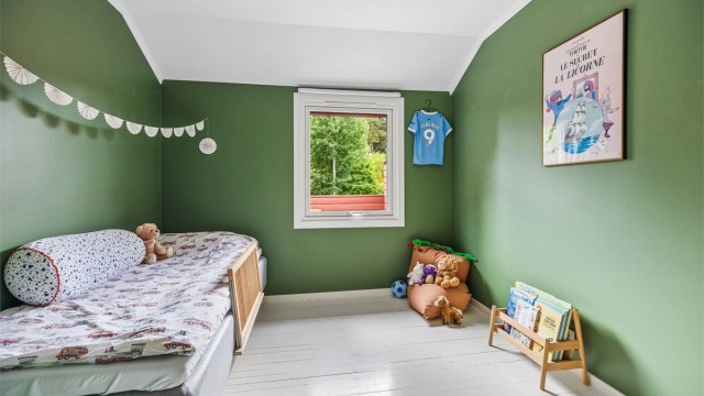 Soverom med plass til seng og oppbevaringsmøbler.