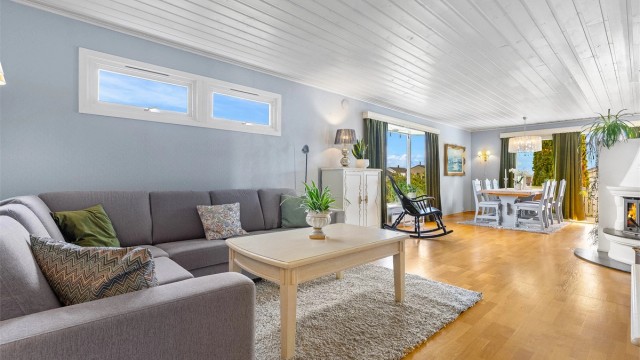 Romslig og lys stue i åpen løsning mot spisestuen.