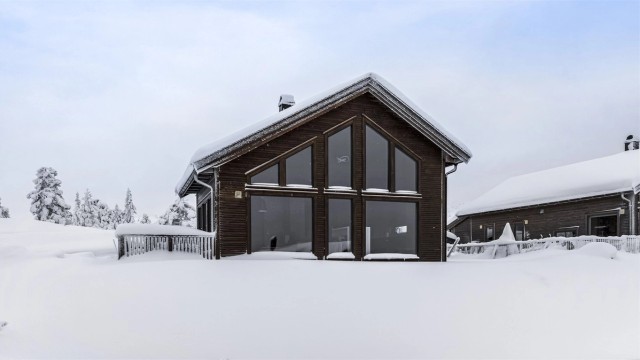 Flott og moderne hytte med store vindusflater og åpen himling inne