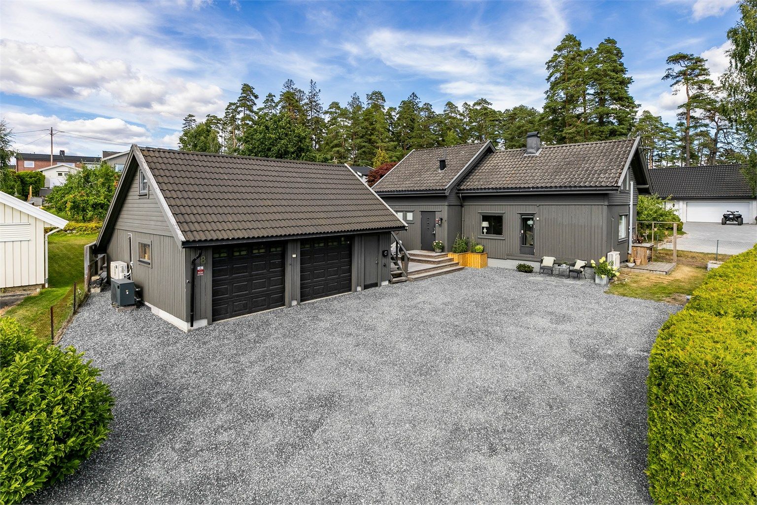 Lader til EL-bil er montert på garasjens yttervegg, mot gårdsplassen.