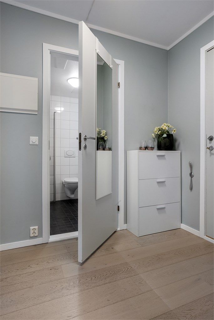 Man møtes av en innbydende entré med parkett på gulv og malte veggflater.