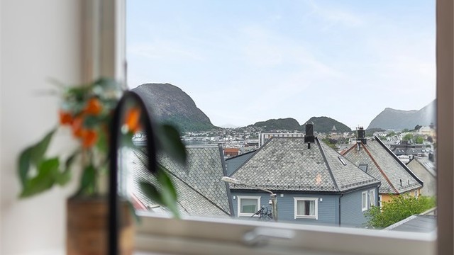 Fra kjøkkenvinduet er det sjarmerende utsikt over skifertak, Sukkertoppen og Godøyfjellet