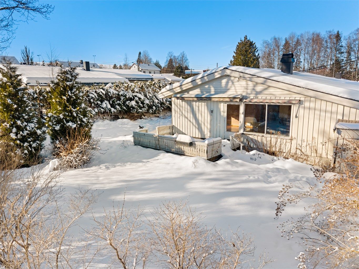 Enebolig fra 1975 med en tilnærmet flat tomt med plenarealer og diverse beplantning.