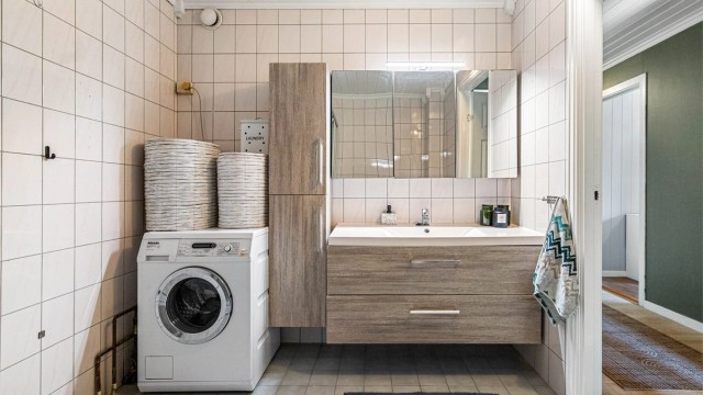 Badet er romslig, med fliser på gulv og vegger. Det er varmekabler i gulvet.
