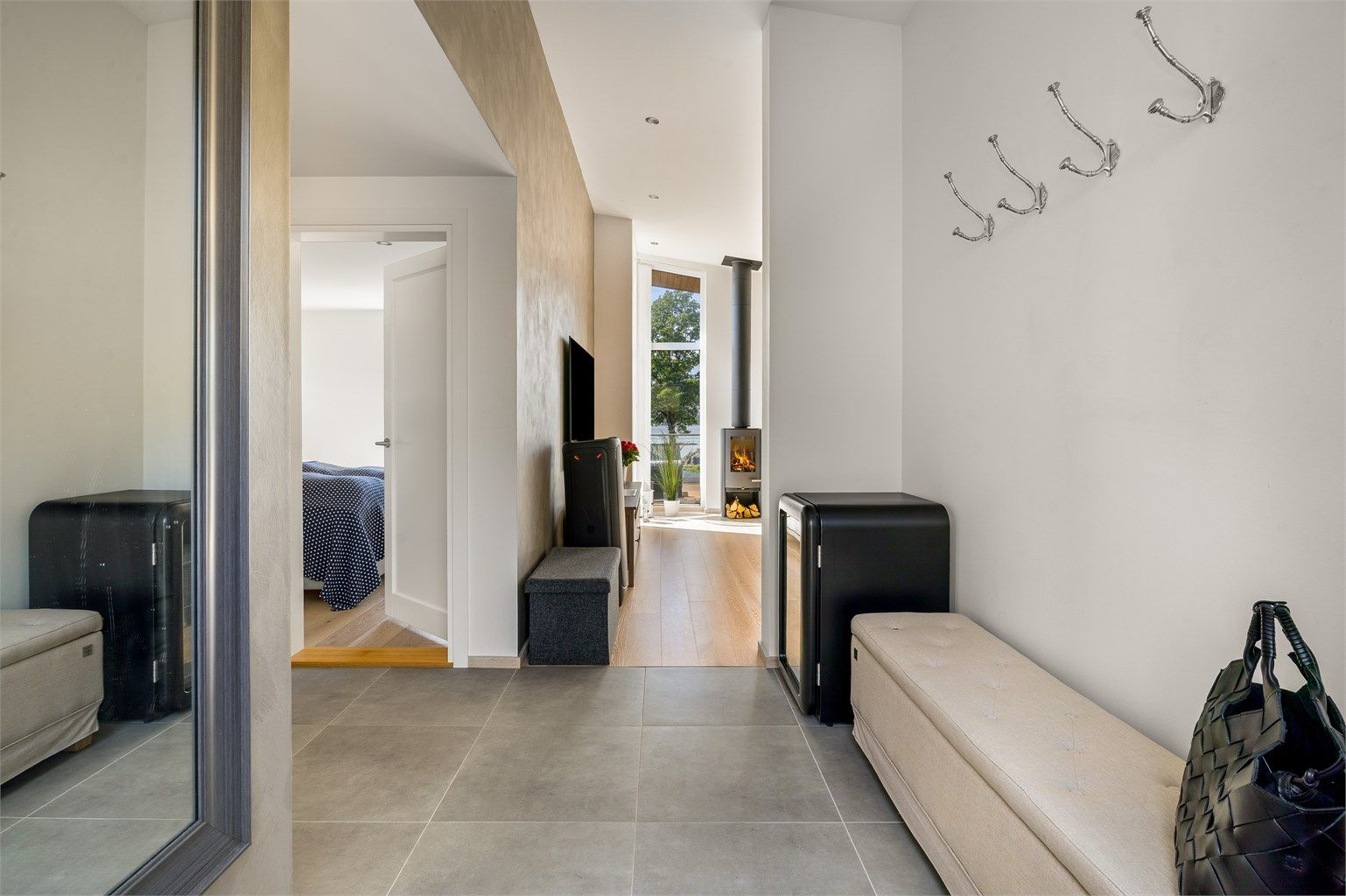 GLIMRENDE LØSNING: Fra utsiden kommer man rett inn i gangen, der det kort vei til toalettet. Med flislagt gang og bad er det lov å gå på do med sko på bena.