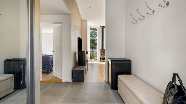 GLIMRENDE LØSNING: Fra utsiden kommer man rett inn i gangen, der det kort vei til toalettet. Med flislagt gang og bad er det lov å gå på do med sko på bena.