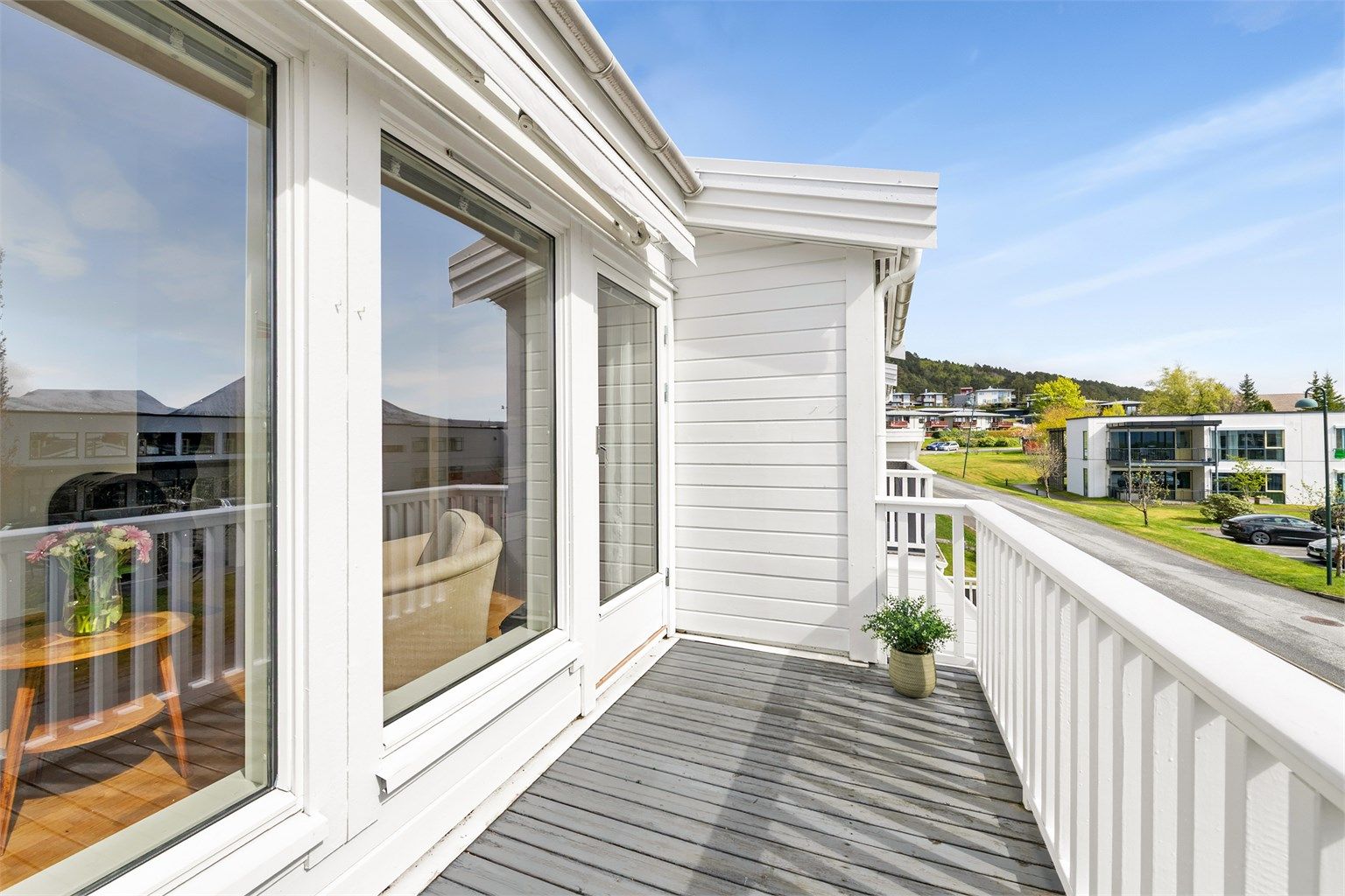 Balkongen har utgang fra stuen og er belagt med terrassebord.