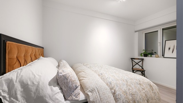 Lyst soverom med laminat på gulv, gulvvarme og plass til dobbeltseng.