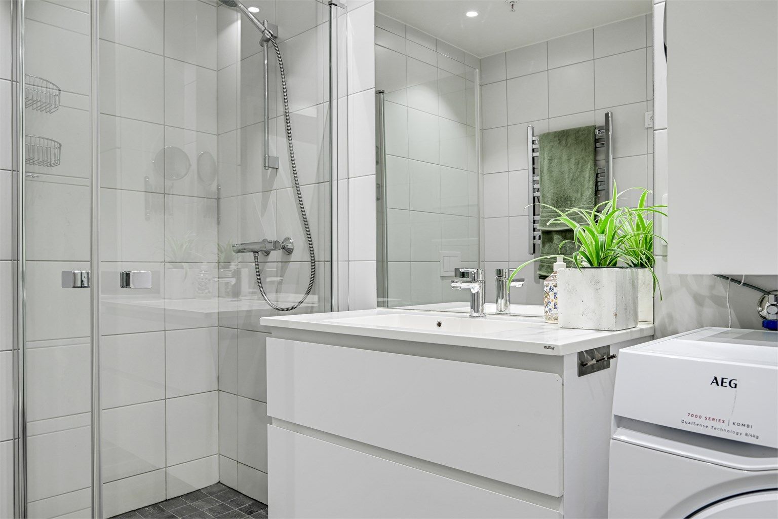 Badet er romslig med dusj og wc samt en nisje med opplegg til vaskemaskin og tørketrommel. 