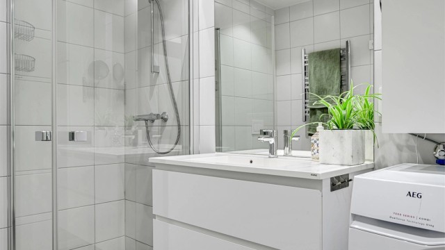 Badet er romslig med dusj og wc samt en nisje med opplegg til vaskemaskin og tørketrommel.