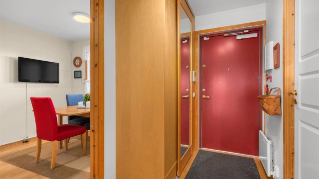 Entréen har tre-stavs parkett på gulvet og en praktisk skyvedørsgarderobe med speilfronter.